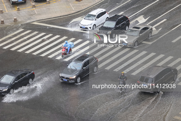 Vehicles are driving through heavy rain in the West Coast New Area of Qingdao, Shandong province, China, on July 16, 2024. 