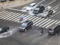 Vehicles are driving through heavy rain in the West Coast New Area of Qingdao, Shandong province, China, on July 16, 2024. (