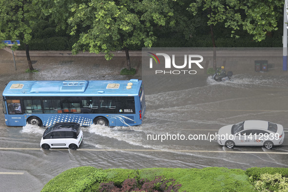 Vehicles are driving through heavy rain in the West Coast New Area of Qingdao, Shandong province, China, on July 16, 2024. 