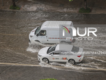 Vehicles are driving through heavy rain in the West Coast New Area of Qingdao, Shandong province, China, on July 16, 2024. (