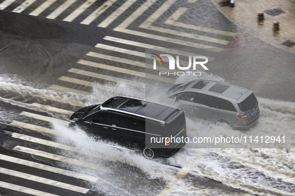 Vehicles are driving through heavy rain in the West Coast New Area of Qingdao, Shandong province, China, on July 16, 2024. 