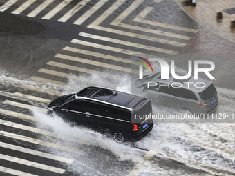 Vehicles are driving through heavy rain in the West Coast New Area of Qingdao, Shandong province, China, on July 16, 2024. (