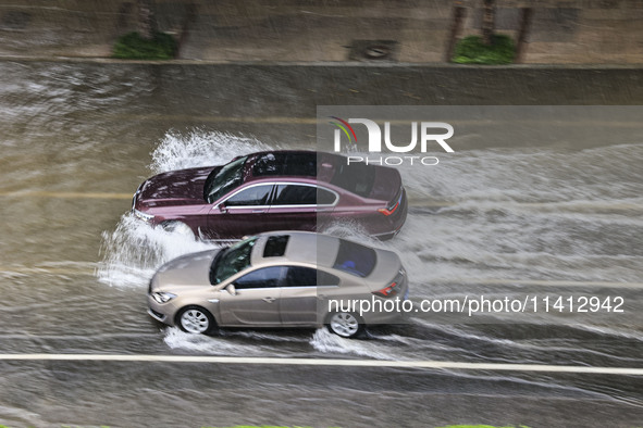 Vehicles are driving through heavy rain in the West Coast New Area of Qingdao, Shandong province, China, on July 16, 2024. 