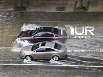 Vehicles are driving through heavy rain in the West Coast New Area of Qingdao, Shandong province, China, on July 16, 2024. (