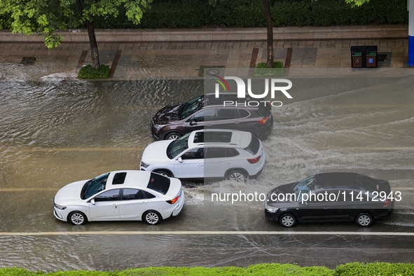 Vehicles are driving through heavy rain in the West Coast New Area of Qingdao, Shandong province, China, on July 16, 2024. 