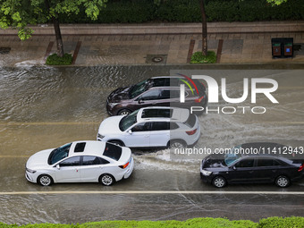 Vehicles are driving through heavy rain in the West Coast New Area of Qingdao, Shandong province, China, on July 16, 2024. (