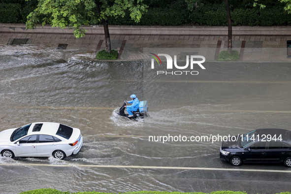 Vehicles are driving through heavy rain in the West Coast New Area of Qingdao, Shandong province, China, on July 16, 2024. 