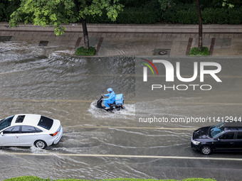 Vehicles are driving through heavy rain in the West Coast New Area of Qingdao, Shandong province, China, on July 16, 2024. (