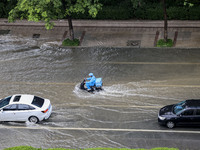 Vehicles are driving through heavy rain in the West Coast New Area of Qingdao, Shandong province, China, on July 16, 2024. (