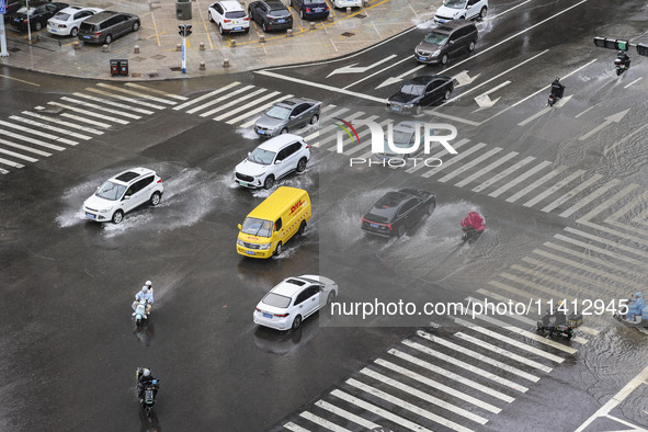 Vehicles are driving through heavy rain in the West Coast New Area of Qingdao, Shandong province, China, on July 16, 2024. 