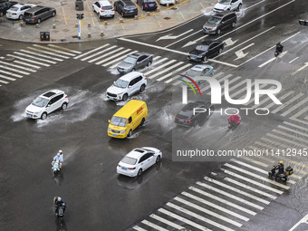 Vehicles are driving through heavy rain in the West Coast New Area of Qingdao, Shandong province, China, on July 16, 2024. (