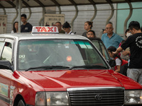 A taxi cab is stopping at a taxi stop in Hong Kong, on July 16, 2024. (