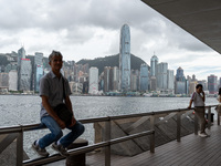 A man is sitting at the promenade in front of the Hong Kong Skyline in Hong Kong, on July 16, 2024. (