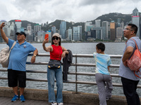 People are taking photos with the Hong Kong Skyline in Hong Kong, on July 16, 2024. (