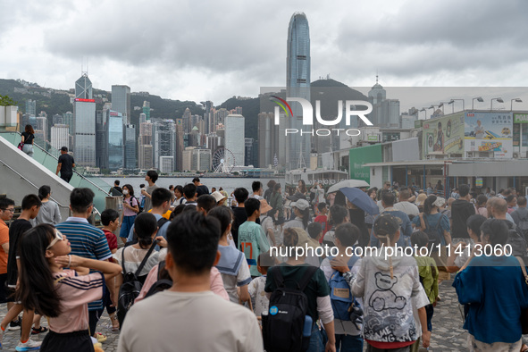 People are at Tsim Sha Tsui Promenade in Hong Kong, on July 16, 2024. 