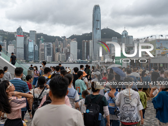 People are at Tsim Sha Tsui Promenade in Hong Kong, on July 16, 2024. (