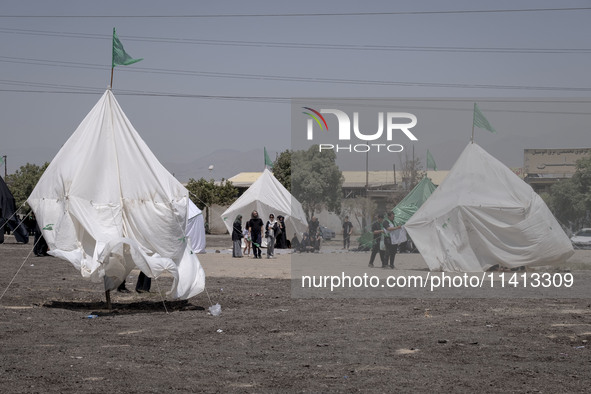 Tents that are being set up in an area, serving as symbols of the tents of Imam Hussein and his family, are being pictured during a religiou...