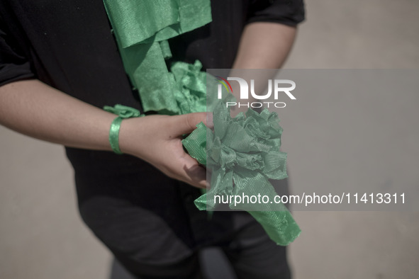 A young Iraqi boy living in Iran is holding prayer symbols during a religious festival to commemorate Ashura in the Dolatabad neighborhood i...