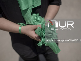 A young Iraqi boy living in Iran is holding prayer symbols during a religious festival to commemorate Ashura in the Dolatabad neighborhood i...