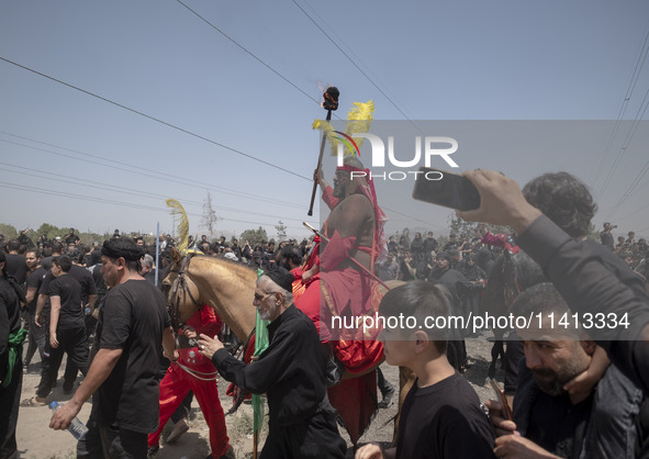 An Iraqi man living in Iran is riding a horse while performing in a religious festival to commemorate Ashura in the Dolatabad neighborhood i...