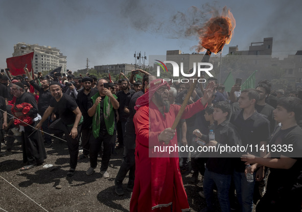 An Iraqi man living in Iran is carrying a torch while performing in a religious festival to commemorate Ashura in the Dolatabad neighborhood...