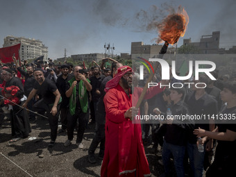 An Iraqi man living in Iran is carrying a torch while performing in a religious festival to commemorate Ashura in the Dolatabad neighborhood...