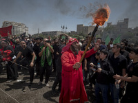 An Iraqi man living in Iran is carrying a torch while performing in a religious festival to commemorate Ashura in the Dolatabad neighborhood...