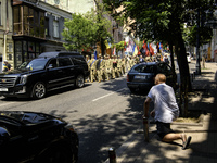 A man is kneeling as the funeral procession for Mykola Kokhanivskyi, commander of the OUN (Organisation of Ukrainian Nationalists) volunteer...