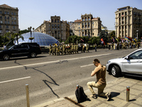 A man is kneeling as the funeral procession for Mykola Kokhanivskyi, commander of the OUN (Organisation of Ukrainian Nationalists) volunteer...