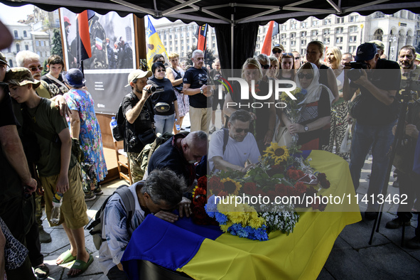 People are kneeling at the coffin of Mykola Kokhanivskyi, commander of the OUN (Organisation of Ukrainian Nationalists) volunteer battalion,...