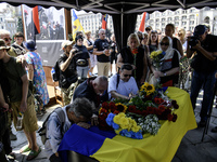 People are kneeling at the coffin of Mykola Kokhanivskyi, commander of the OUN (Organisation of Ukrainian Nationalists) volunteer battalion,...