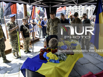 A woman is kneeling at the coffin of Mykola Kokhanivskyi, commander of the OUN (Organisation of Ukrainian Nationalists) volunteer battalion,...