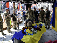 A woman is kneeling at the coffin of Mykola Kokhanivskyi, commander of the OUN (Organisation of Ukrainian Nationalists) volunteer battalion,...