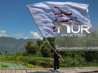 A Kashmiri Shiite Muslim child is waving a religious flag during a Muharram procession on the ninth day of Ashura in the interiors of Dal La...