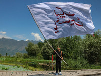 A Kashmiri Shiite Muslim child is waving a religious flag during a Muharram procession on the ninth day of Ashura in the interiors of Dal La...