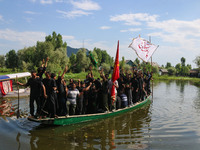 Kashmiri Shiite Muslim mourners are participating in a Muharram procession on a boat on the ninth day of Ashura in the interiors of Dal Lake...