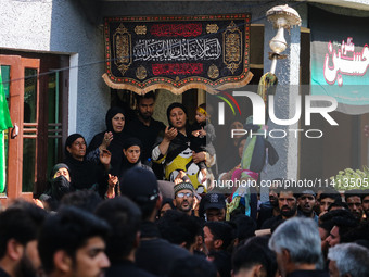 Kashmiri Shiite Muslim mourners are participating in a Muharram procession on the ninth day of Ashura in the interiors of Dal Lake in Srinag...