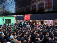 Kashmiri Shiite Muslim mourners are participating in a Muharram procession on the ninth day of Ashura in the interiors of Dal Lake in Srinag...