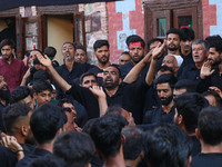 Kashmiri Shiite Muslim mourners are participating in a Muharram procession on the ninth day of Ashura in the interiors of Dal Lake in Srinag...