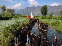 Kashmiri Shiite Muslim mourners are participating in a Muharram procession on boats on the ninth day of Ashura in the interiors of Dal Lake...