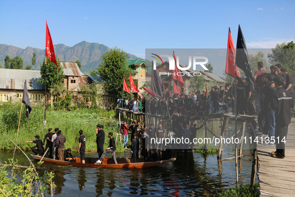 Kashmiri Shiite Muslim mourners are participating in a Muharram procession on a boat on the ninth day of Ashura in the interiors of Dal Lake...