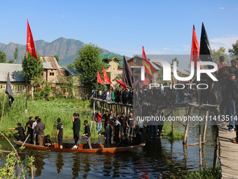 Kashmiri Shiite Muslim mourners are participating in a Muharram procession on a boat on the ninth day of Ashura in the interiors of Dal Lake...