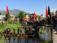 Kashmiri Shiite Muslim mourners are participating in a Muharram procession on a boat on the ninth day of Ashura in the interiors of Dal Lake...