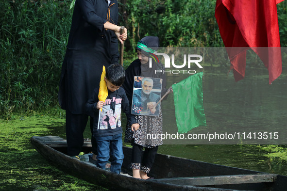 A Kashmiri Shiite Muslim child is holding a placard showing a picture of Iranian commander Qasem Soleimani during a Muharram procession on t...