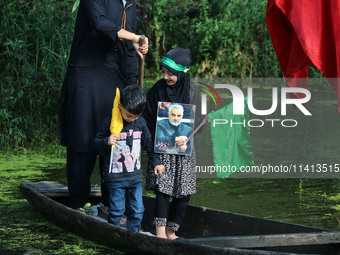 A Kashmiri Shiite Muslim child is holding a placard showing a picture of Iranian commander Qasem Soleimani during a Muharram procession on t...