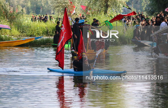 A Kashmiri Shiite, along with his kids, is rowing his kayak as they are taking part in a Muharram procession on the ninth day of Ashura in t...