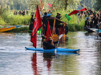 A Kashmiri Shiite, along with his kids, is rowing his kayak as they are taking part in a Muharram procession on the ninth day of Ashura in t...