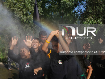 Kashmiri Shiite Muslim mourners are receiving a cold water spray during a Muharram procession on the ninth day of Ashura in the interiors of...