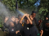 Kashmiri Shiite Muslim mourners are receiving a cold water spray during a Muharram procession on the ninth day of Ashura in the interiors of...