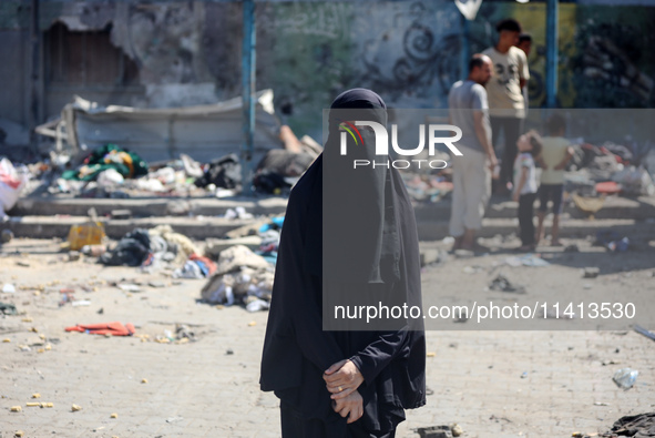 Palestinians are inspecting a UN school sheltering displaced people, following an Israeli strike, amid the Israel-Hamas conflict, in Nuseira...